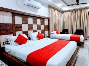 达兰萨拉Hotel King Castle Central Heated & Air cooled的两张位于酒店客房的床铺,配有红色枕头