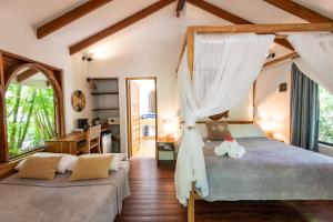 圣塔特蕾莎海滩Villas Almendros的一间卧室设有两张床和窗户。