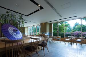 富士吉田市海兰德水疗度假酒店的一间带桌椅和蓝伞的餐厅