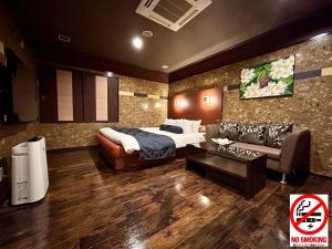 东京Hotel Asian Color (Adult Only)的酒店客房,配有床和沙发