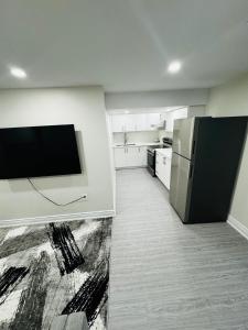 布兰普顿C&M Beautiful Basement的带冰箱的厨房和墙上的电视