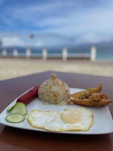 波尔多·格尼拉Manalo's Lodge and Restaurant的海滩上一盘带鸡蛋和肉类的食物