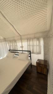 SariSari Highlands的卧室配有白色的床和桌子