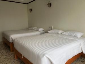 帕朗特里蒂斯Edge Resort, Yogyakarta的两张睡床彼此相邻,位于一个房间里