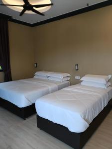 淡马鲁Perry Barr La Ganta Residence的卧室内的两张床,配有吊扇