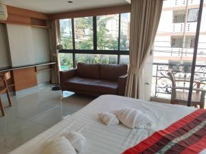 Ban Zong KatiamL18 residence แอลสิบแปด เรสซิเดนซ์的一间卧室配有一张床、一张沙发和一个窗口
