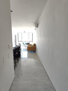 马萨特兰¡Departamento a 5 minutos del Malecón!的走廊设有白色墙壁、沙发和椅子