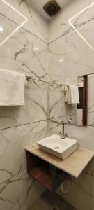 阿格拉MD GRAND HOTEL & RESORT的一间带水槽和大理石墙的浴室