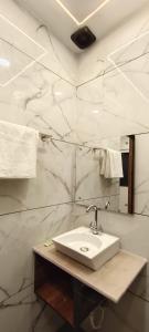 阿格拉MD GRAND HOTEL & RESORT的一间带水槽和白色大理石墙壁的浴室