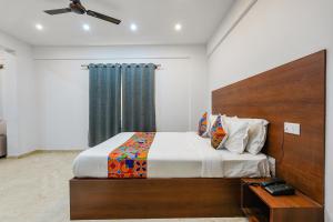 班加罗尔FabHotel Tree Suites的一间卧室配有一张带木制床头板的床