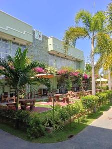 巴旺Marand Resort -Highway的前面有长椅和棕榈树的建筑