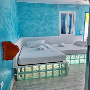 冯塔尼比安奇Suite House L'Isola Che Non C'è的蓝色墙壁客房的两张床