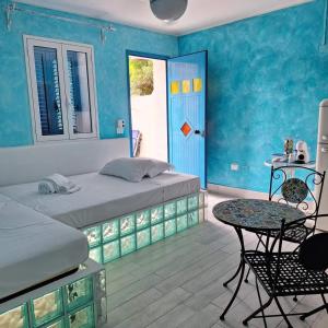 冯塔尼比安奇Suite House L'Isola Che Non C'è的一间卧室设有两张床、一张桌子和一扇门