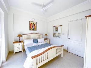 RevoraB&F Meadows - Your Premier Apartment Hotel的一间白色卧室,配有床和2个床头柜