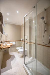普拉托魅力四射酒店的一间带玻璃淋浴和卫生间的浴室