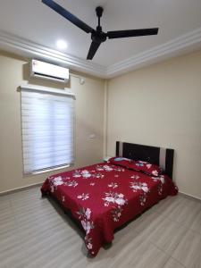 关丹Villa Tok Wan的一间卧室配有一张带红色毯子的床