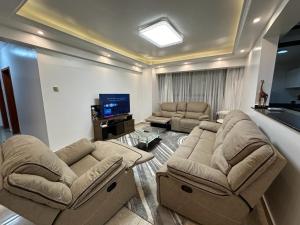 内罗毕Home Croft Nairobi的客厅配有两张沙发和一台电视
