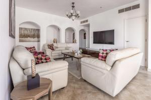 迪拜Frank Porter - Al Badia 2的客厅配有2张白色沙发和电视