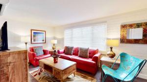 摩押Downtown Cozy Home Base - Purple Sage 6的客厅配有红色的沙发和椅子
