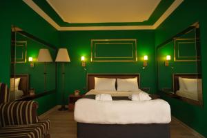 迪亚巴克尔Malabadi Hotel的绿色卧室,配有床和绿色的墙壁