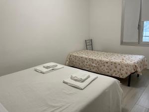 奥里奥阿塞里奥Apartment Orio Volta的客房设有2张床,配有白色的床单和毛巾。