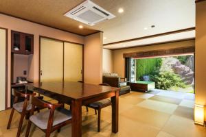 笛吹市Beautiful Japanese Garden Kagetsu的一间带木桌和椅子的用餐室