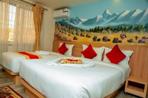 加德满都Hotel Kedarnath的一间卧室设有两张床,墙上挂着一幅画
