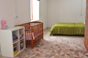LiguriPaganamaa puhkemaja ja peosaal的一间卧室配有婴儿床和一张床