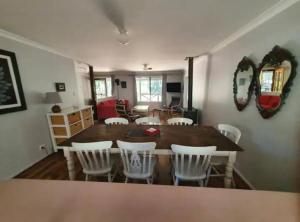 德韦灵阿普Begonia Cottage的用餐室配有大型木桌和白色椅子