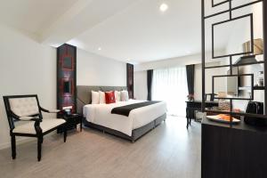 曼谷Villa De Pranakorn的一间大卧室,配有一张床和一把椅子
