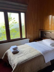ÇaykaraLahza Hills Resort的一间卧室配有一张大床和两条毛巾
