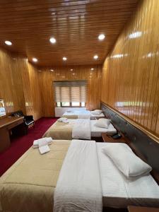 ÇaykaraLahza Hills Resort的木墙房间的一排床位