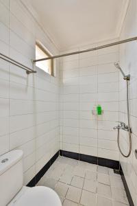 CinereCinere Inn & Residence的带淋浴和卫生间的白色浴室