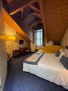 都灵萨沃意亚别墅酒店的一间卧室配有一张大床和一张书桌