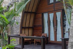 吉利阿尔Omah Gili Hotel的小木屋 - 带桌椅的甲板