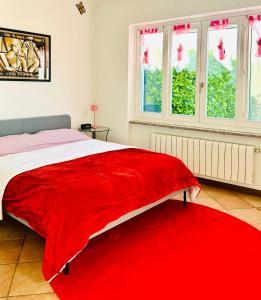 佩尔莱多Le Palme House Rifugio Romantico & late check-out的卧室配有红色毯子,床上设有窗户