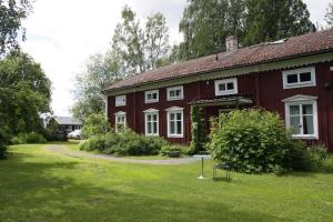 吕勒奥Ralph Lundstengården (Farmhouse Lodge)的一间红色的房子,有白色的窗户和院子
