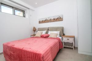 阿凡杜弗朗西斯和格雷戈里豪华别墅的一间卧室配有一张带粉红色棉被的床