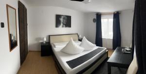 坎皮纳Pensiunea Bavaria Campina的一间卧室配有带白色床单和枕头的床。