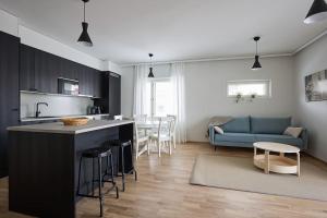 图尔库Saunallinen uudiskohde Logomon vieressä, ilmainen autohallipaikka + Wi-Fi的厨房以及带蓝色沙发的起居室。