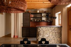 卡斯泰尔贝洛Oberortlhof - Juval的厨房设有石制柜台和木制天花板。