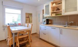 美因塔尔Maintal Apartment 1的厨房配有白色橱柜、桌子和水槽。