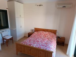 凯法利尼亚岛Villa Margaux Karavados的一间卧室配有一张带红白毯子的床
