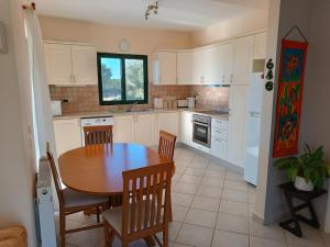 凯法利尼亚岛Villa Margaux Karavados的厨房配有木桌和椅子