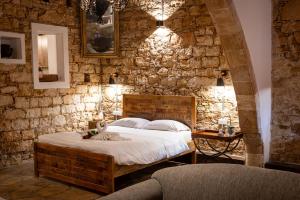 洛弗欧奴萨传统精品宾馆的一间卧室设有一张床和石墙