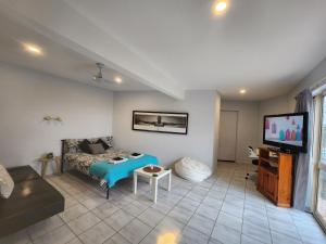 黄金海岸Self Contained Guesthouse for 7ppl, w Pool的带沙发和电视的客厅