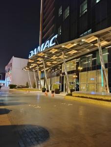 利雅德برج داماك الرياض DAMAC Towers Riyadh的大楼前的一个空停车位