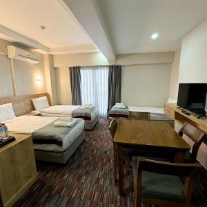 Konakmojo otel的酒店客房设有两张床和一张桌子。