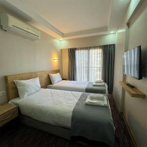 Konakmojo otel的酒店客房设有两张床和窗户。
