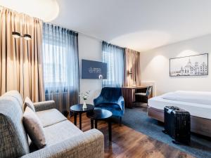 斯图加特皇家酒店的酒店客房配有沙发床和书桌